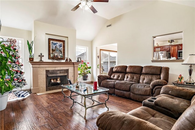 living room with ceiling fan, vaulted ceiling, a fireplace, and dark hardwood / wood-style flooring