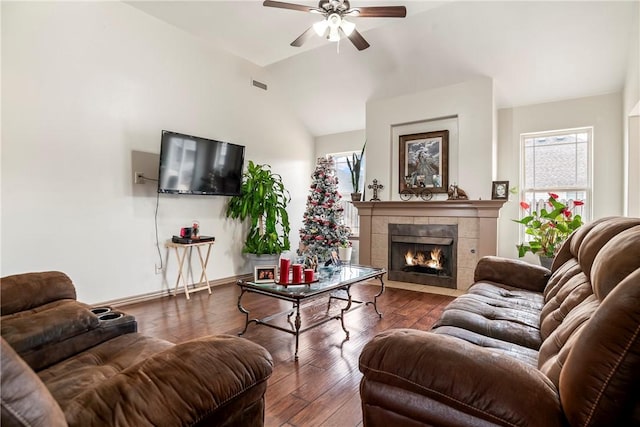 living room with ceiling fan, vaulted ceiling, a fireplace, and dark hardwood / wood-style flooring