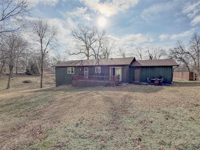 ranch-style home with a deck and a front lawn