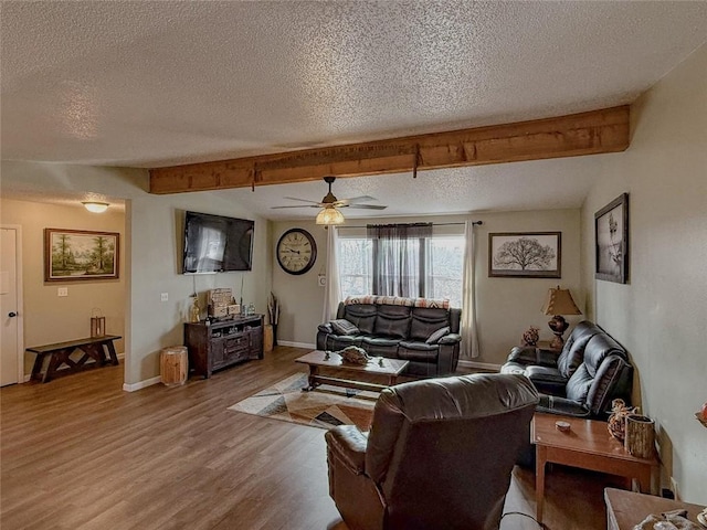 living room featuring beamed ceiling, hardwood / wood-style floors, and a textured ceiling