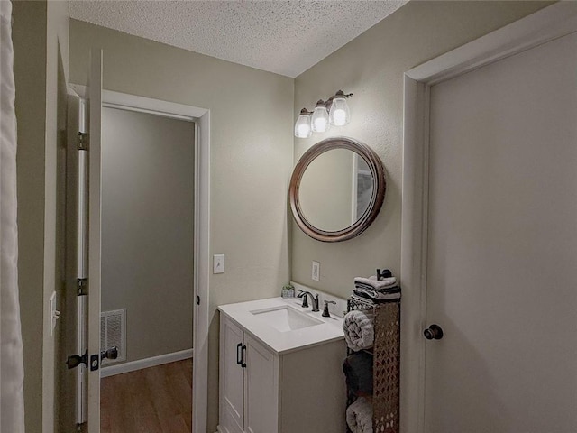 bathroom featuring vanity, hardwood / wood-style floors, and a textured ceiling