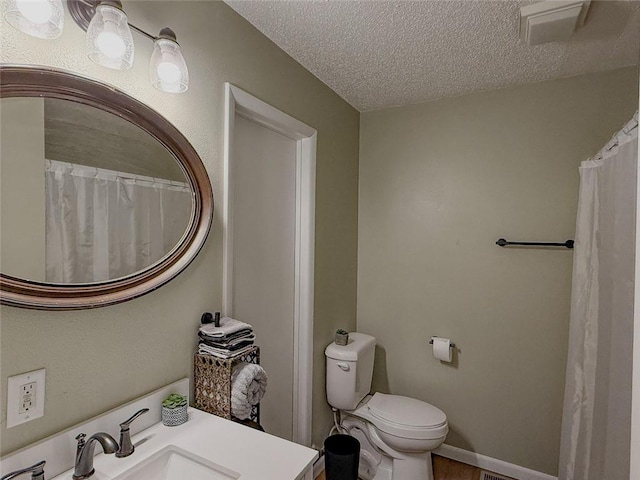 bathroom with vanity, a textured ceiling, hardwood / wood-style flooring, and toilet