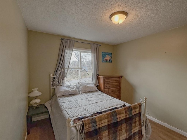 bedroom with a textured ceiling and light wood-type flooring