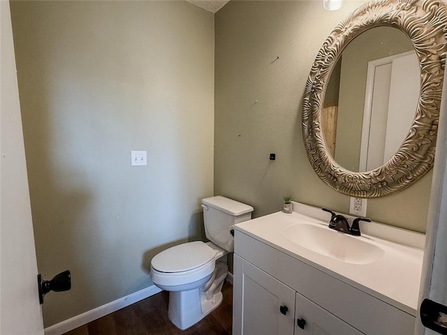 bathroom featuring toilet, vanity, and hardwood / wood-style flooring