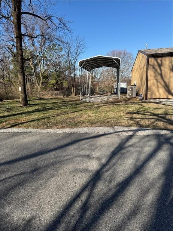 view of yard featuring a detached carport, an outdoor structure, and a pole building