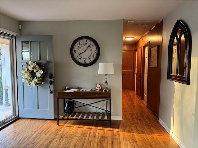 entryway with hardwood / wood-style floors, baseboards, and visible vents