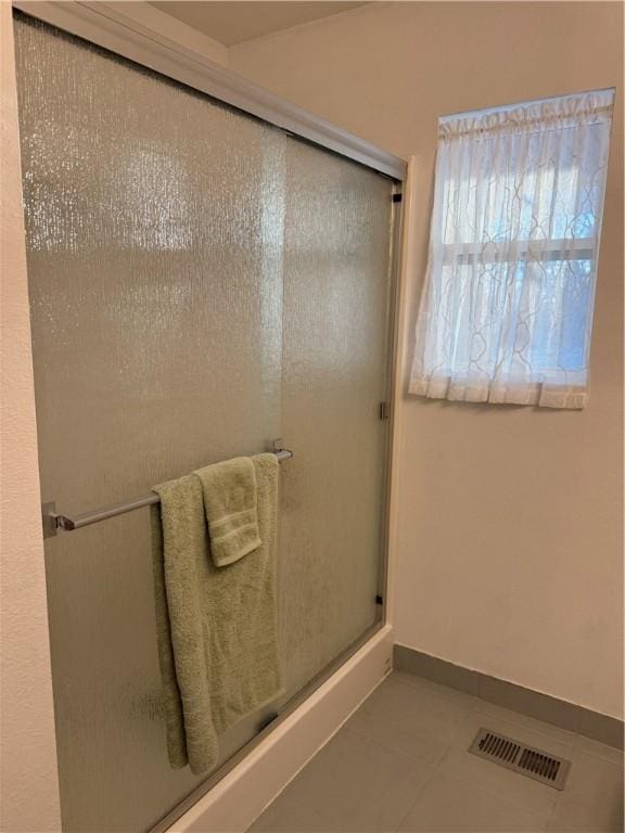 bathroom featuring a shower stall, baseboards, visible vents, and tile patterned floors