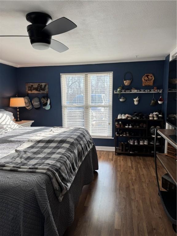 bedroom featuring ceiling fan, a textured ceiling, and wood finished floors