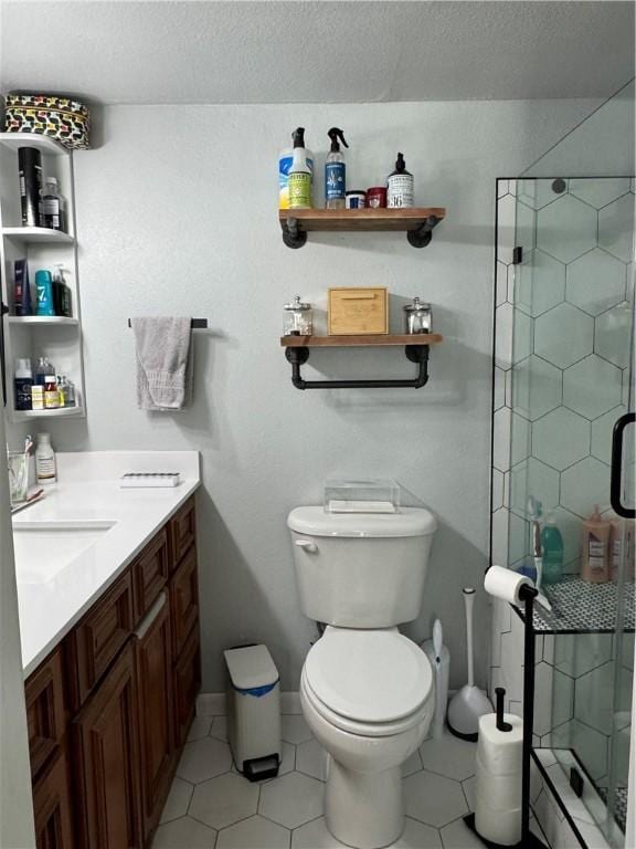 bathroom with a shower stall, toilet, and vanity