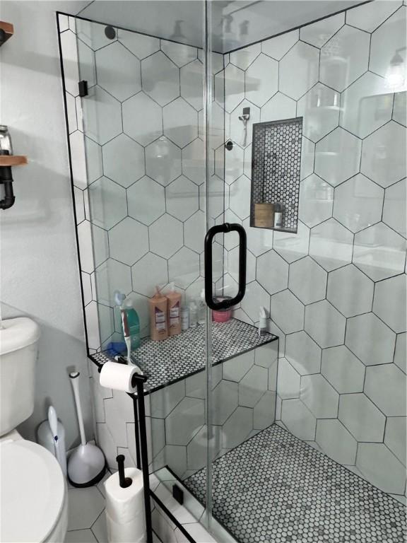 full bathroom with toilet and a stall shower