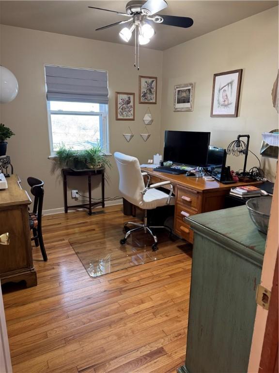 home office featuring baseboards, ceiling fan, and light wood finished floors