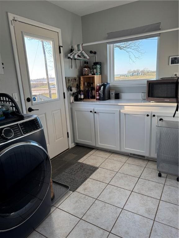 laundry room featuring washer / dryer and light tile patterned flooring