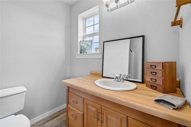 bathroom with hardwood / wood-style floors, vanity, and toilet