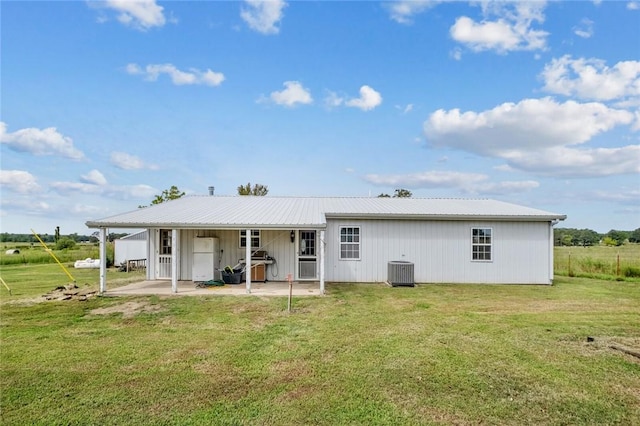 back of house with central AC unit, a yard, and a patio