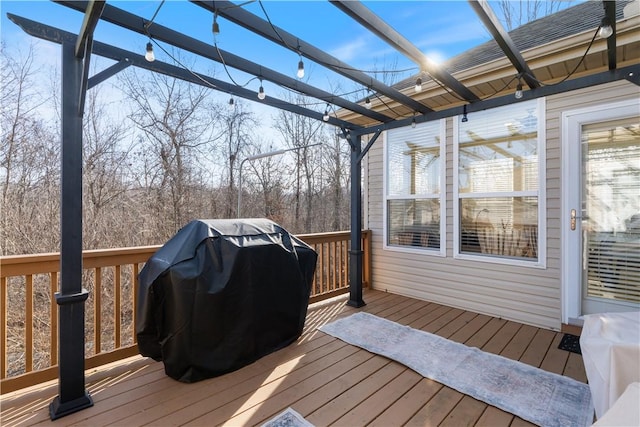 wooden deck featuring area for grilling and a pergola