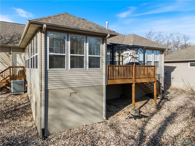 view of side of home with a wooden deck and central air condition unit