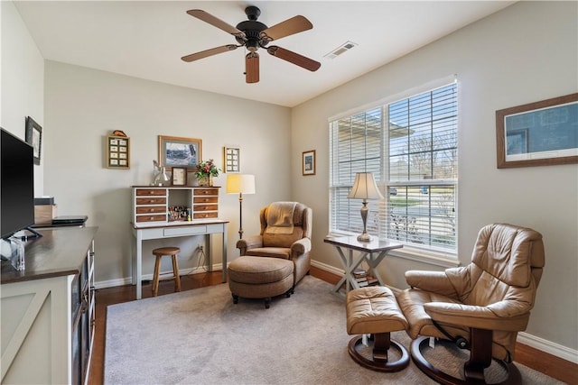 living area with ceiling fan, plenty of natural light, and hardwood / wood-style flooring