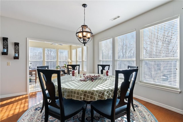 dining space featuring wood-type flooring and a notable chandelier