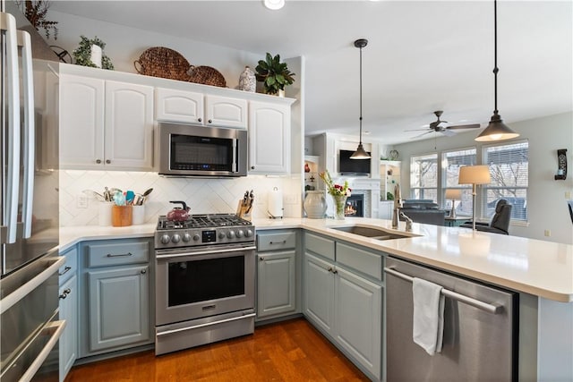 kitchen with pendant lighting, sink, kitchen peninsula, and stainless steel appliances