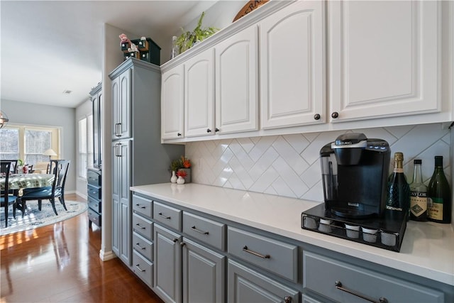 kitchen featuring decorative backsplash, white cabinetry, gray cabinets, and dark hardwood / wood-style floors