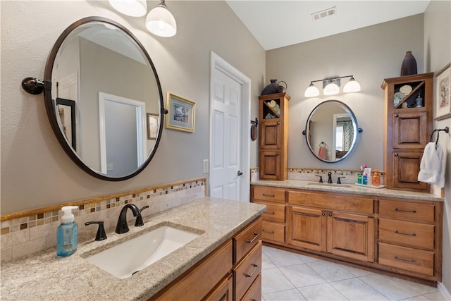 bathroom with tasteful backsplash, tile patterned flooring, and vanity