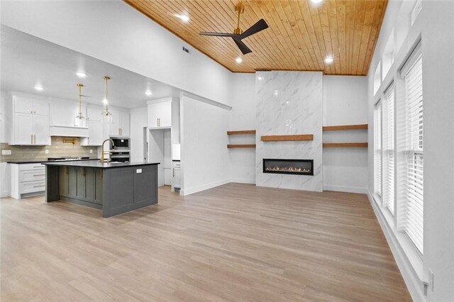 kitchen featuring pendant lighting, wooden ceiling, a kitchen island with sink, ceiling fan, and white cabinetry