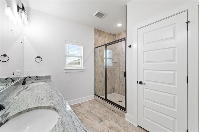 bathroom with a shower with door and vanity