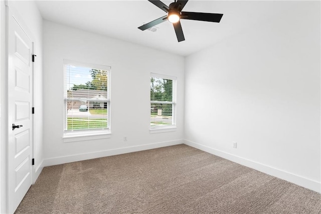 spare room with a wealth of natural light, carpet floors, and ceiling fan