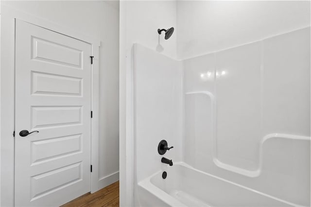 bathroom featuring wood-type flooring and shower / tub combination