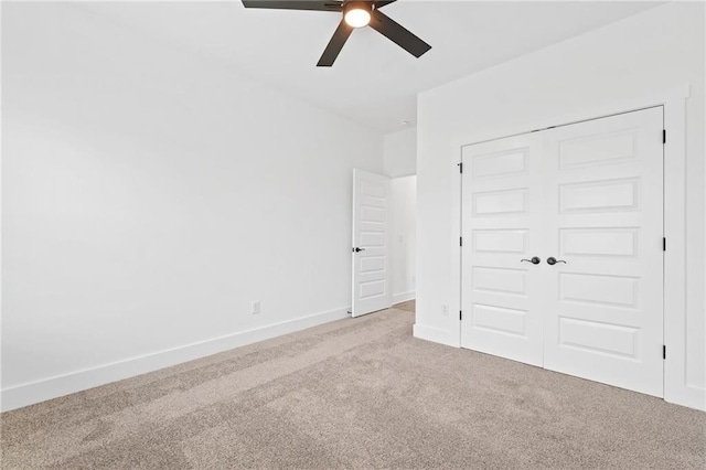 unfurnished bedroom featuring a closet, ceiling fan, and light colored carpet