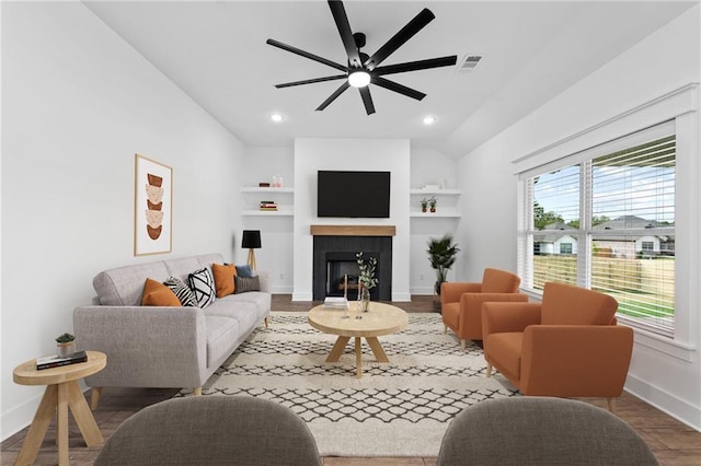 living room with ceiling fan, wood-type flooring, built in features, and lofted ceiling