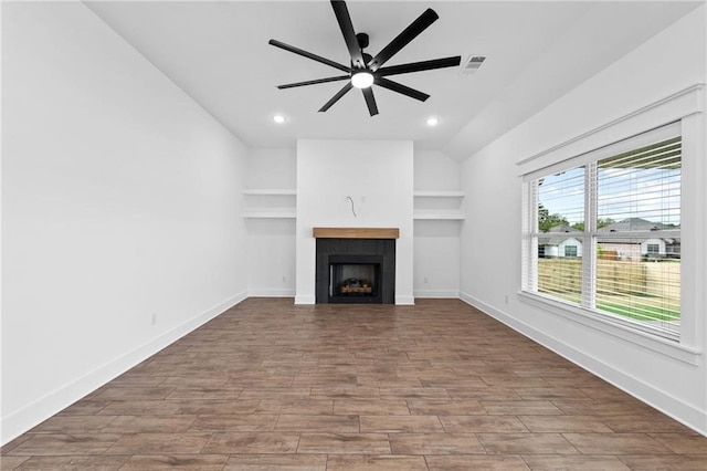 unfurnished living room with ceiling fan and vaulted ceiling