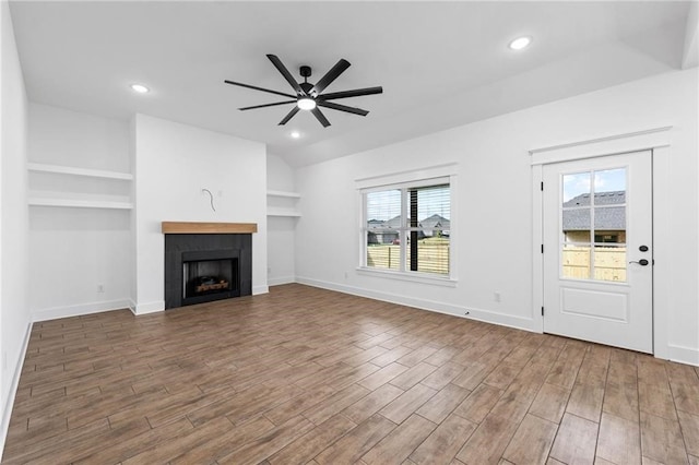 unfurnished living room featuring ceiling fan, a healthy amount of sunlight, and built in features