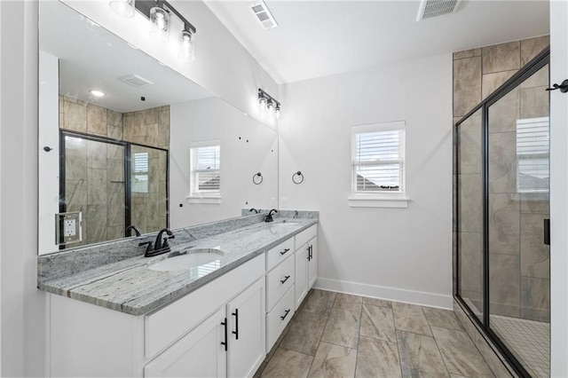 bathroom with a shower with door and vanity