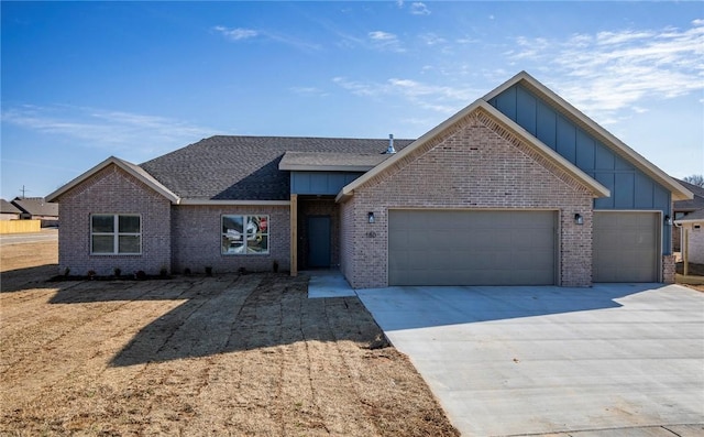 view of front facade with a garage, brick siding, board and batten siding, and concrete driveway