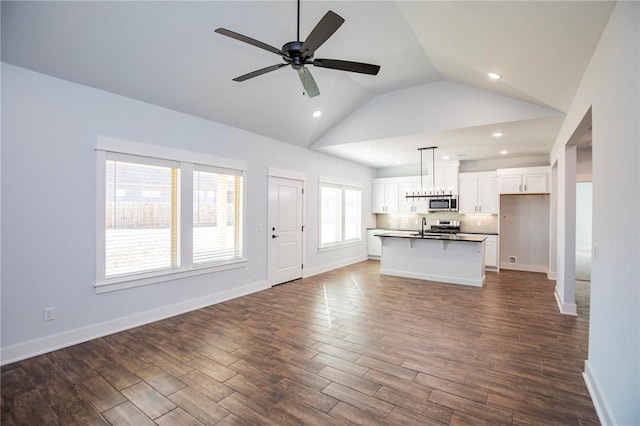 unfurnished living room featuring recessed lighting, dark wood-style flooring, a sink, a ceiling fan, and baseboards