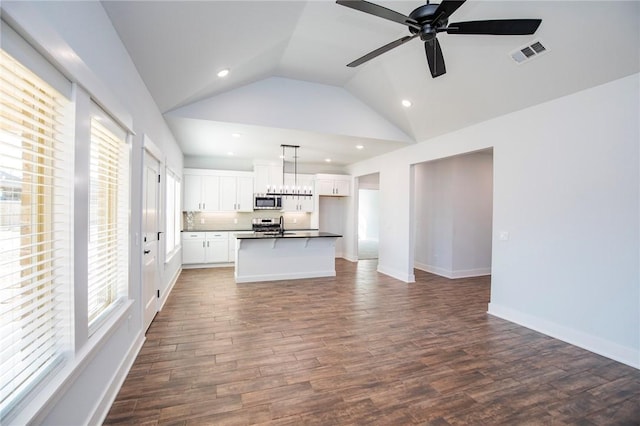 kitchen featuring dark countertops, a wealth of natural light, visible vents, appliances with stainless steel finishes, and open floor plan