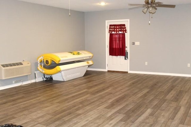 foyer featuring a wall unit AC, ceiling fan, and dark wood-type flooring