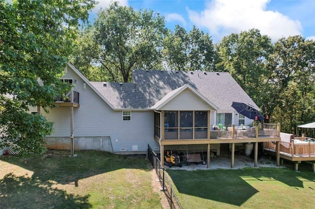 rear view of property featuring a yard, a wooden deck, and a sunroom