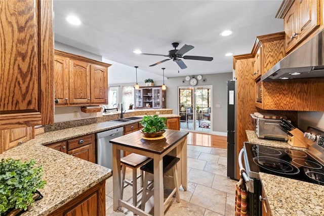 kitchen featuring light stone countertops, appliances with stainless steel finishes, ceiling fan, light tile patterned floors, and hanging light fixtures