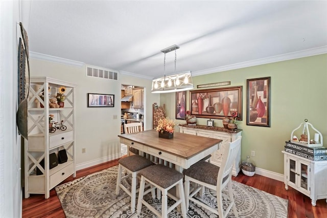 dining area featuring dark hardwood / wood-style flooring and crown molding