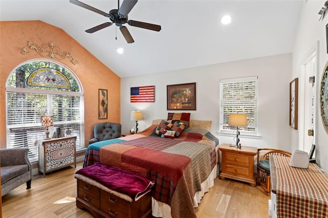 bedroom with multiple windows, light wood-type flooring, vaulted ceiling, and ceiling fan