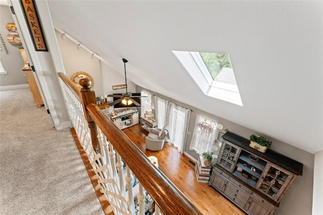 stairway with carpet, ceiling fan, and lofted ceiling with skylight