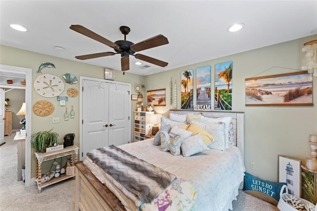 carpeted bedroom featuring ceiling fan and a closet