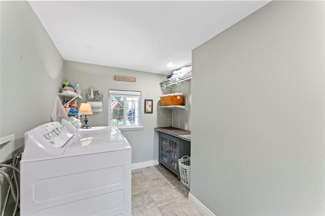 clothes washing area featuring light tile patterned flooring and washer and dryer