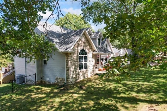 view of side of home with cooling unit and a lawn