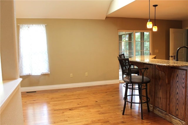 635 Ranchview Rd, Ridgedale, MO 65739 - kitchen featuring light wood-style floors, a kitchen breakfast bar, hanging light fixtures, and light stone countertops