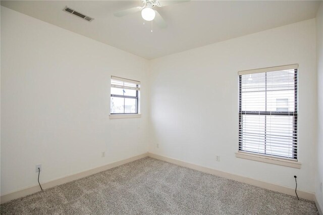 empty room with carpet flooring, plenty of natural light, and ceiling fan