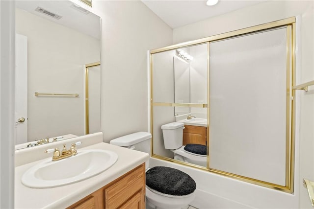 full bathroom featuring vanity, toilet, and shower / bath combination with glass door