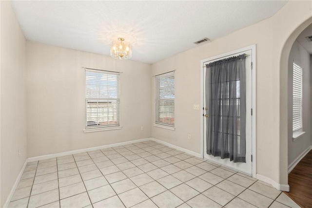 tiled entrance foyer featuring an inviting chandelier